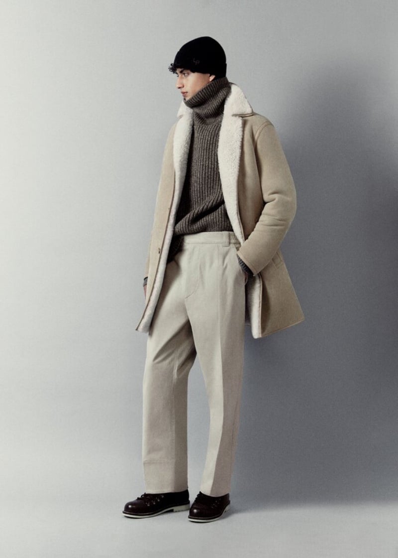 Yoesry Detre dons a winter-ready look with a shearling coat over a chunky turtleneck sweater and tailored pants, complemented by a classic black beanie from Loro Piana.