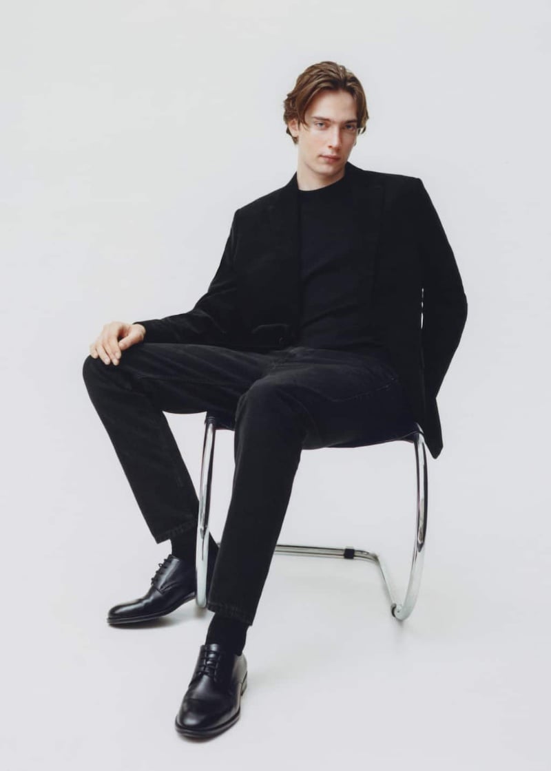 Model Freek Iven wears an all-black Mango ensemble, donning a blazer with corduroy pants.