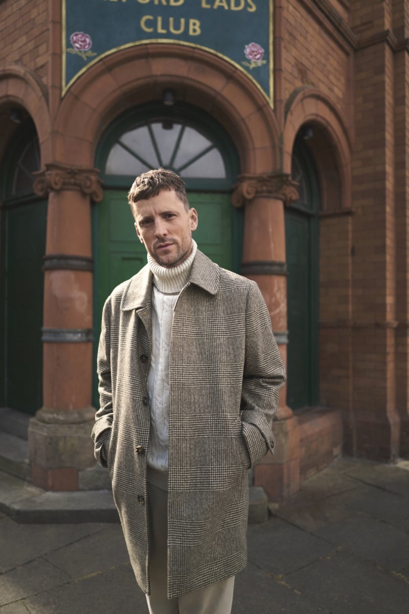 George Barnett channels a timelessness in a herringbone coat over a turtleneck sweater for the M&S fall-winter 2023 campaign.