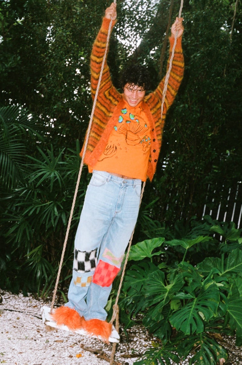Model Carlos Mata sports a Marni for SSENSE graphic orange t-shirt with blue jeans and Fussbett Sabot loafers.