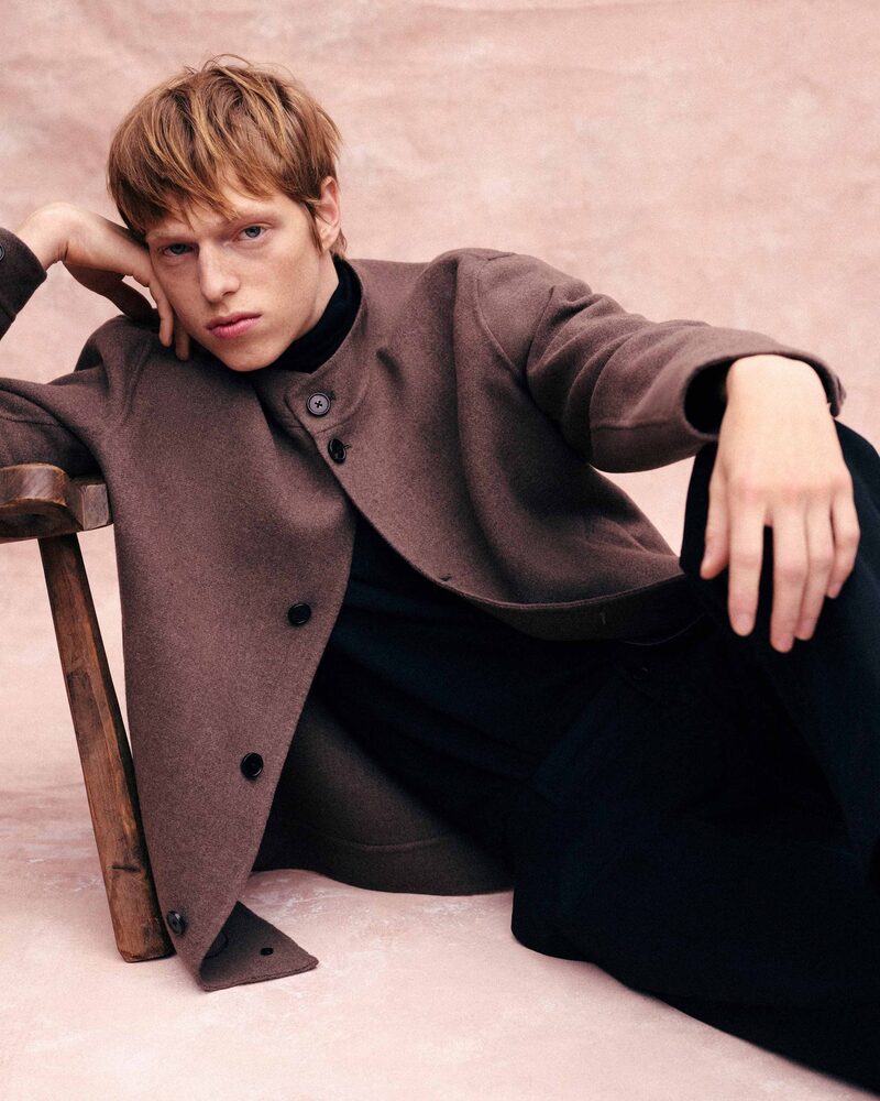 Joseph Uyttenhove strikes a pose in a brown jacket over a black turtleneck, merging effortless style with thoughtful elegance.