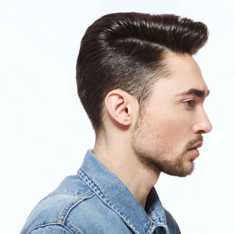 Young man with stylish hairstyle sitting and getting his beard shaved in  barber shop 15291156 Stock Photo at Vecteezy