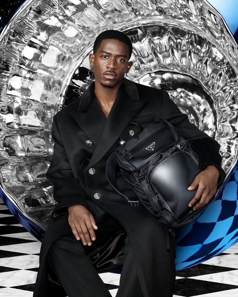 Damson Idris is a sophisticated vision in a double-breasted coat for Prada's holiday 2023 advertisement.