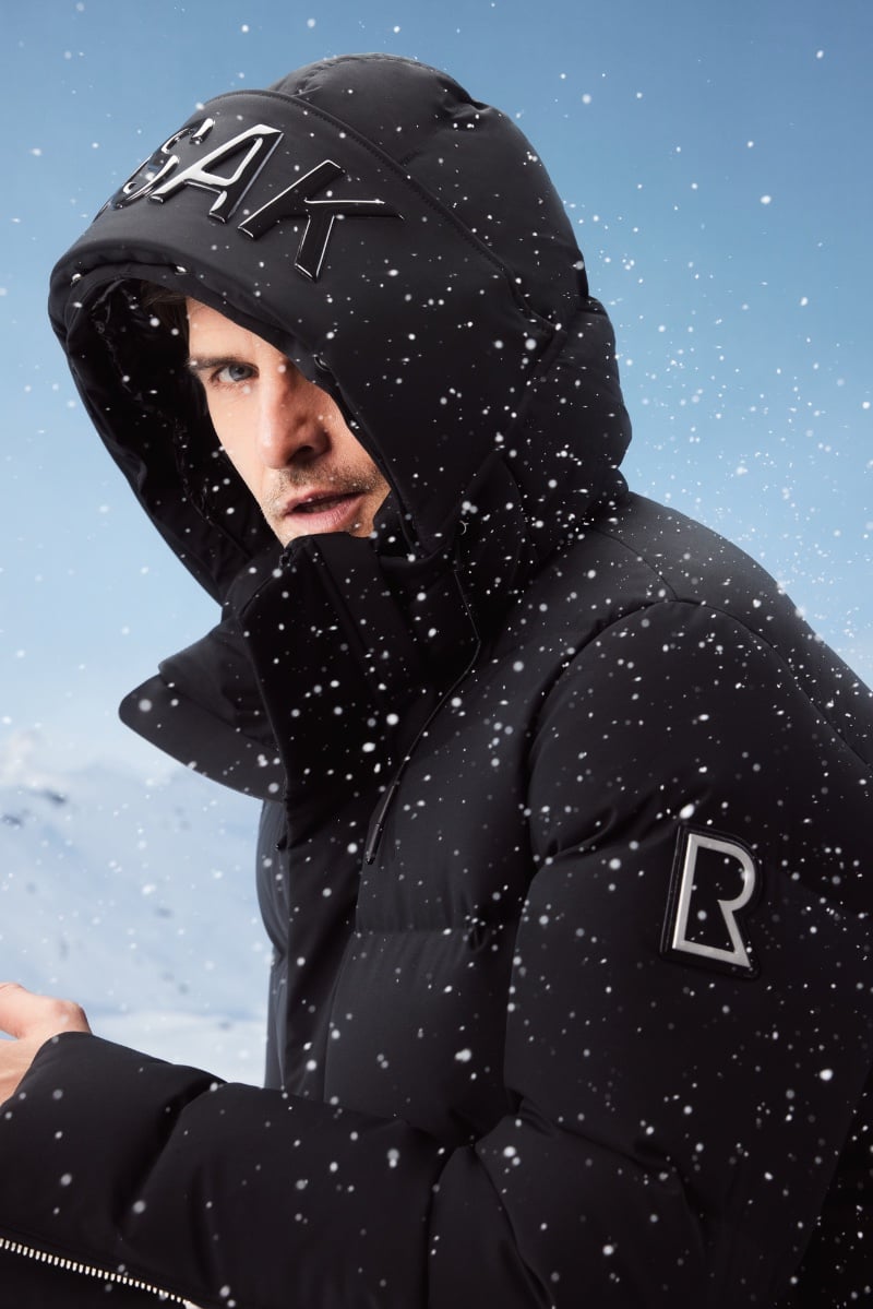 Amidst a snowfall, Johannes Huebl envelops himself in a RUDSAK hooded puffer.