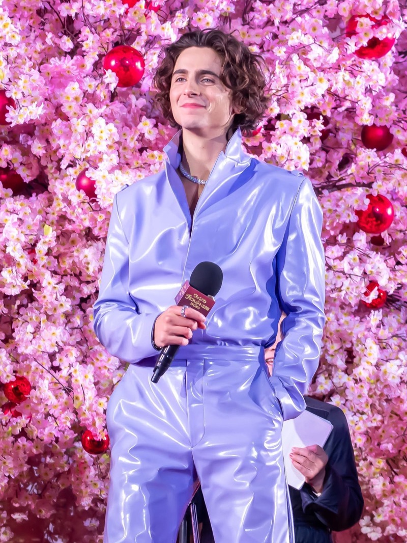 In a sea of cherry blossoms, Timothée Chalamet looks radiant in a lavender ciré Prada suit at the Tokyo premiere of Wonka. 