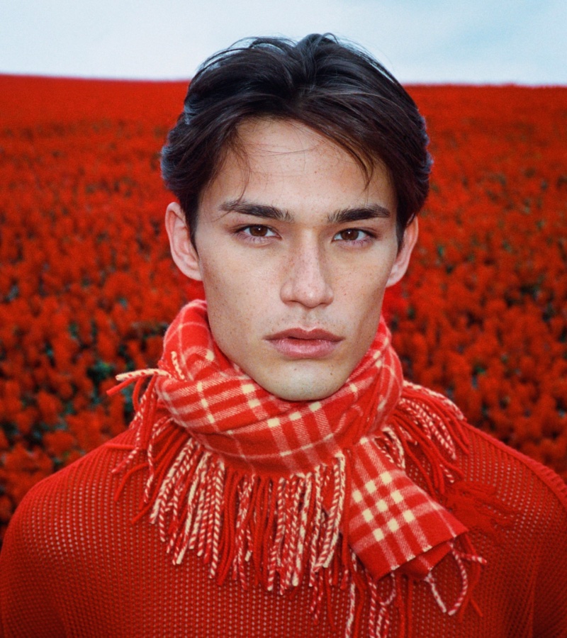 Dressed in red, Alex Schlab dons a tartan scarf and mesh sweater for the Burberry Lunar New Year 2024 campaign. 