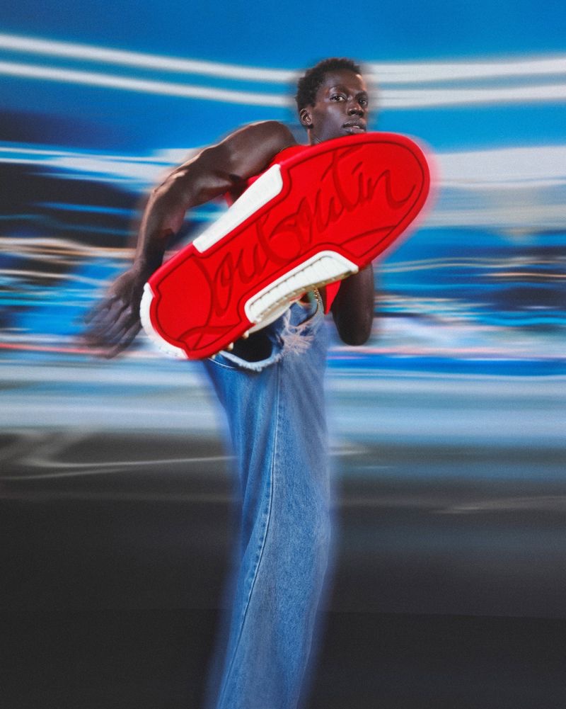 Abdou Ndiaye shows off his red Astroloubi sneaker bottom in the Christian Louboutin campaign.