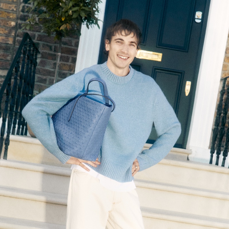 All smiles, Guy Remmers poses with Jimmy Choo's N/S tote for the label's spring 2024 advertisement.