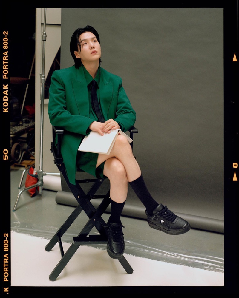 Suga poses for The Narratives, spring-summer 2024 campaign by Valentino, in a striking green short suit.