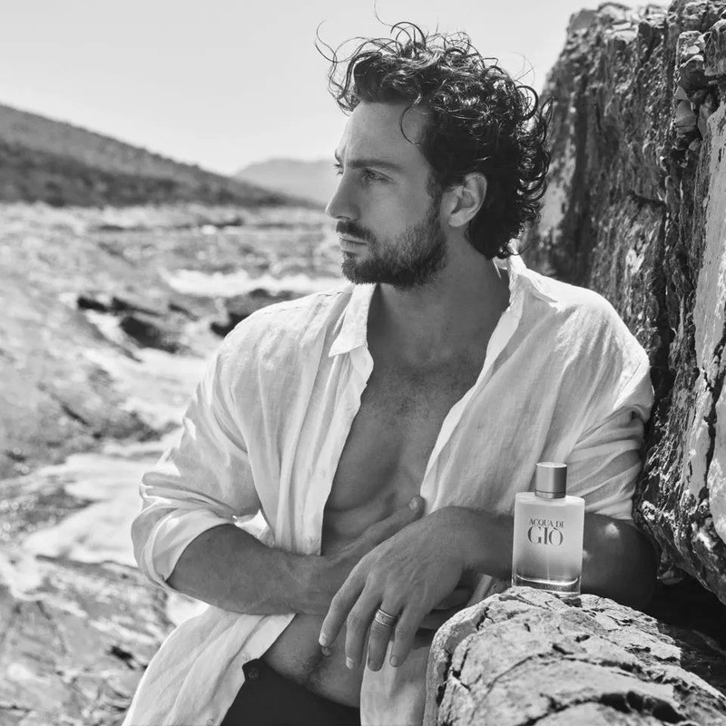 Aaron Taylor-Johnson leans contemplatively beside Giorgio Armani Acqua Di Giò for the fragrance ad.