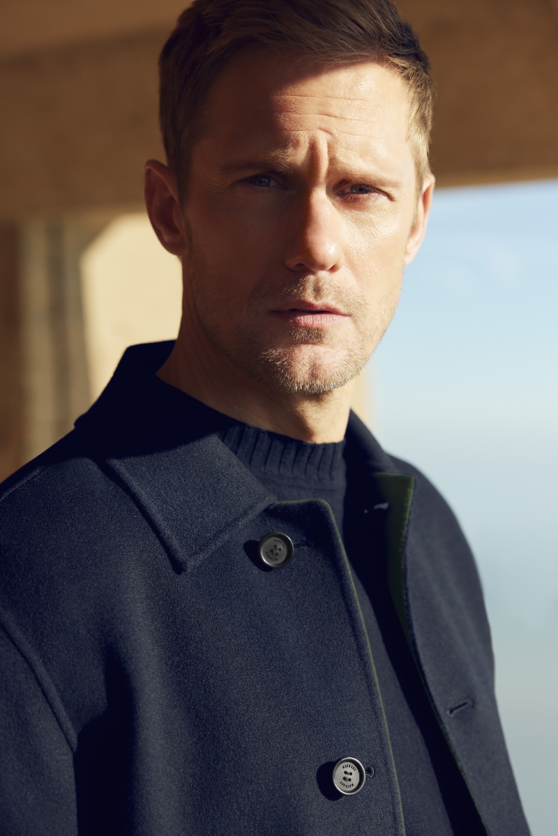 Alexander Skarsgård wears a navy coat for Mackage's spring-summer 2024 advertisement.