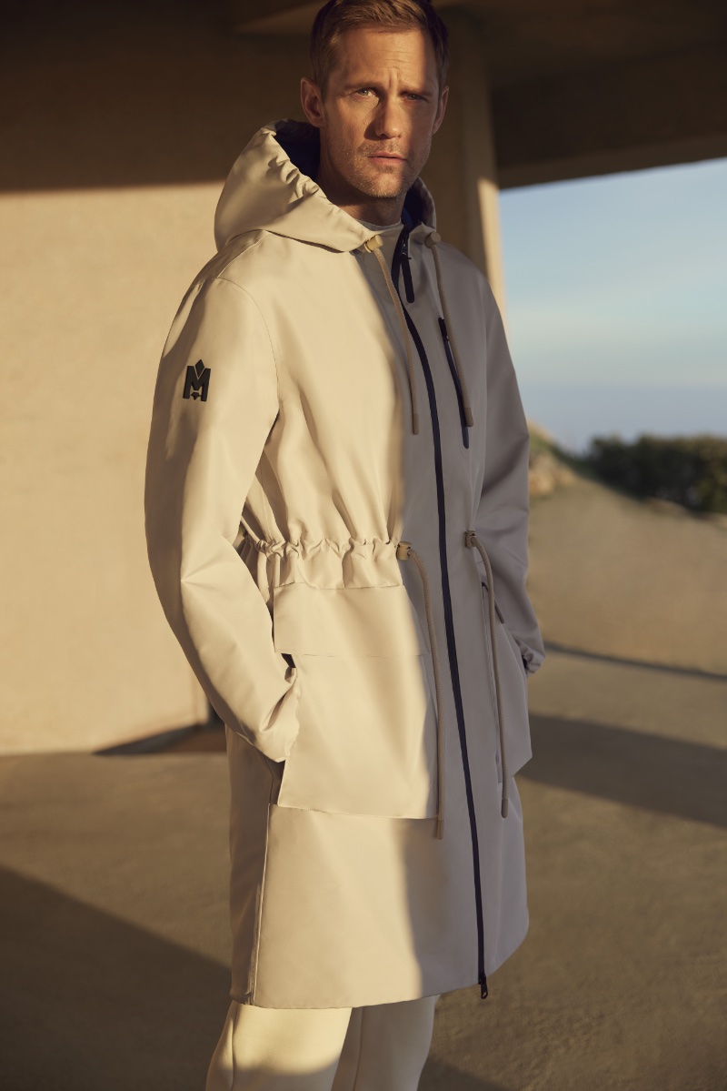 Actor Alexander Skarsgård dons a hooded trench for Mackage's spring-summer 2024 campaign.