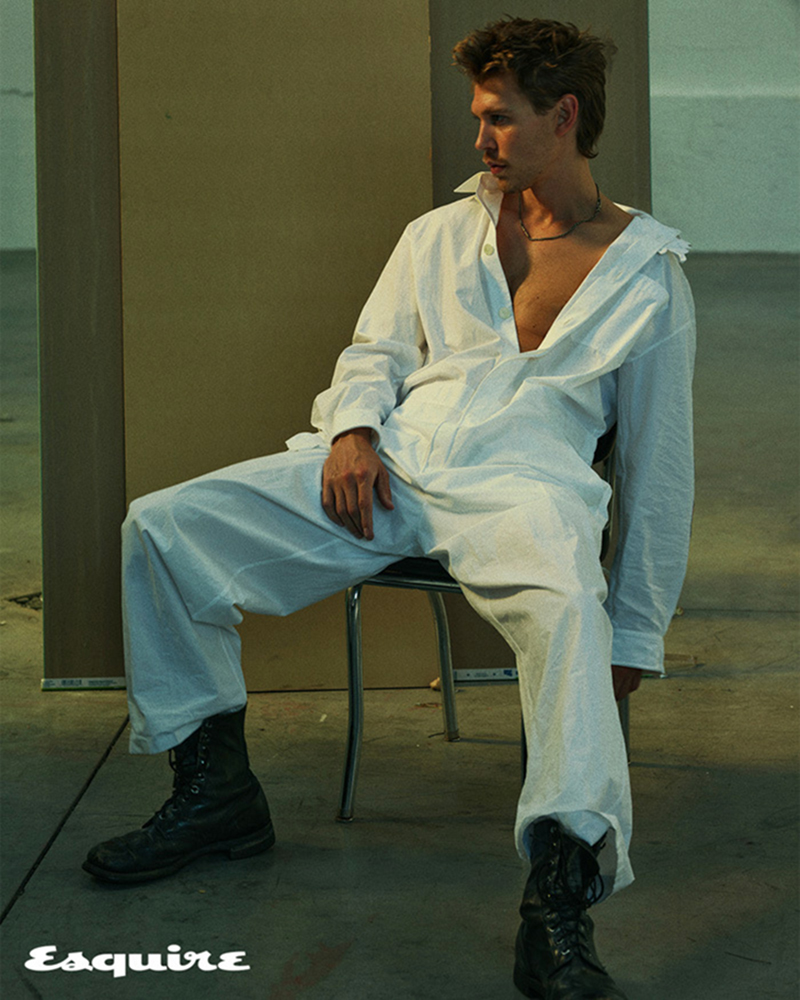 Sitting for a photo, Austin Butler dons a white Valentino jumpsuit with vintage boots and a Werkstatt:München necklace.