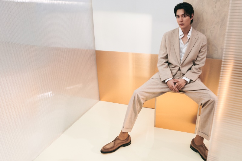 Lee Minho poses against a minimalist backdrop for the BOSS spring-summer 2024 campaign, wearing a beige suit.