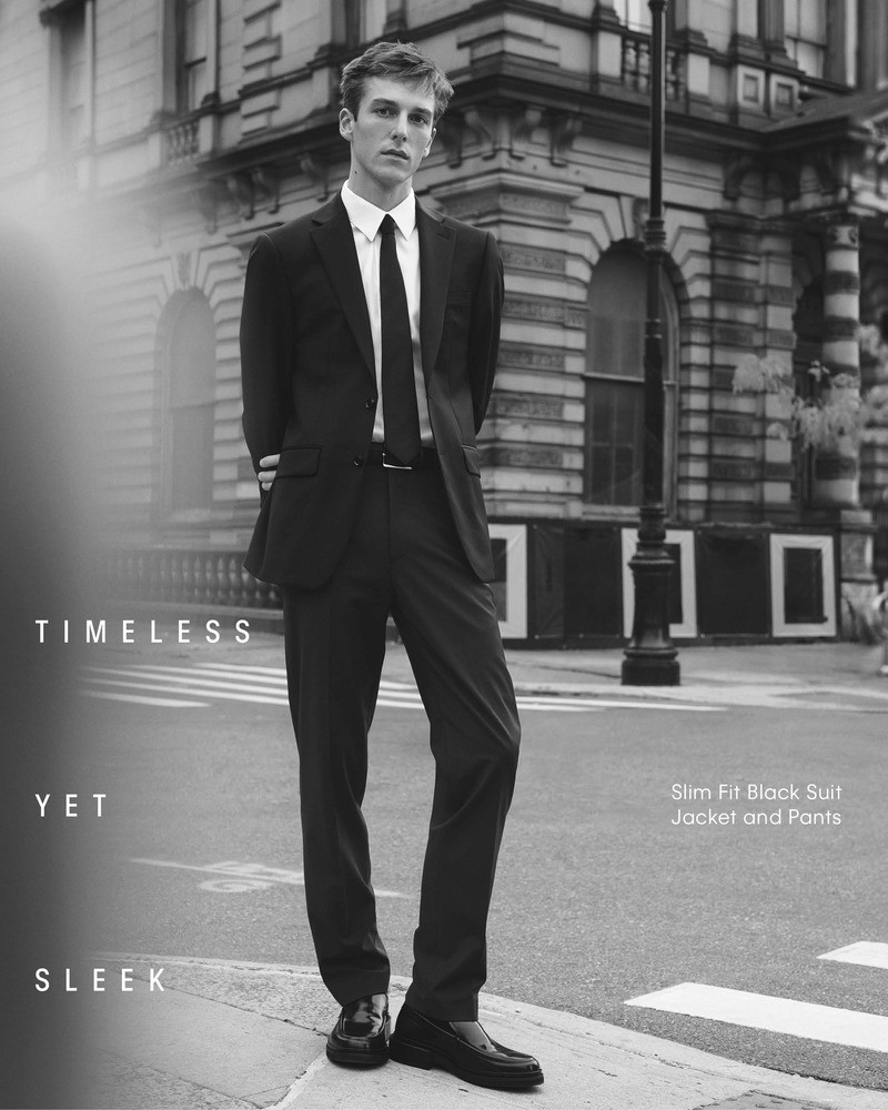 Model Quentin Demeester exudes classic elegance in a slim-fit black suit by Calvin Klein. 
