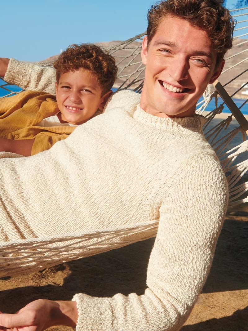 Otto Lotz enjoys a moment of sun-drenched leisure, donning a cozy knit for Canali's spring-summer 2024 campaign.