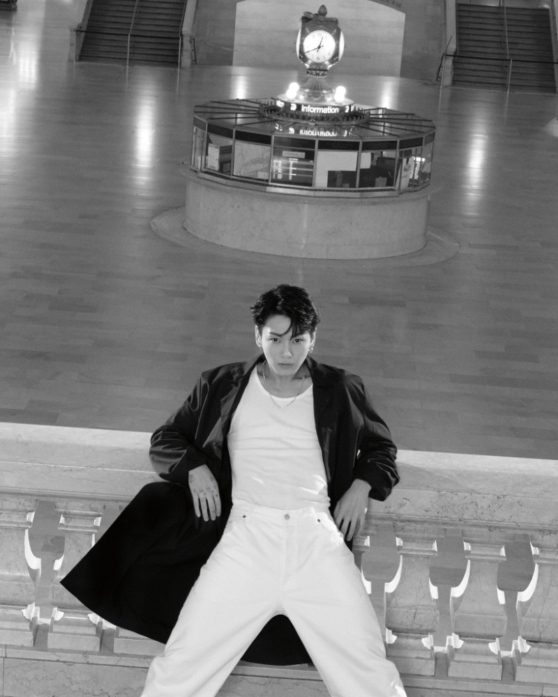 Jung Kook wears a black coat over a white outfit for Calvin Klein's spring 2024 campaign.