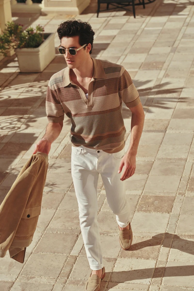 Embracing neutral tones, Adam Sattrup wears a Todd Snyder stripe Montauk polo with relaxed fit 5-pocket chinos and Todd Snyder x Sanders Edwin loafers.