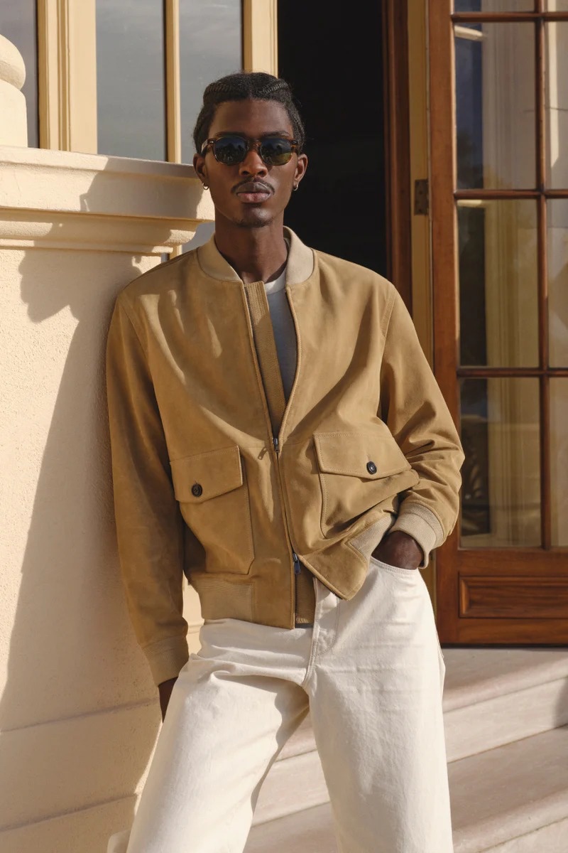 Model Anarcius Jean sports an Italian suede bomber with Japanese relaxed fit selvedge chinos by Todd Snyder.