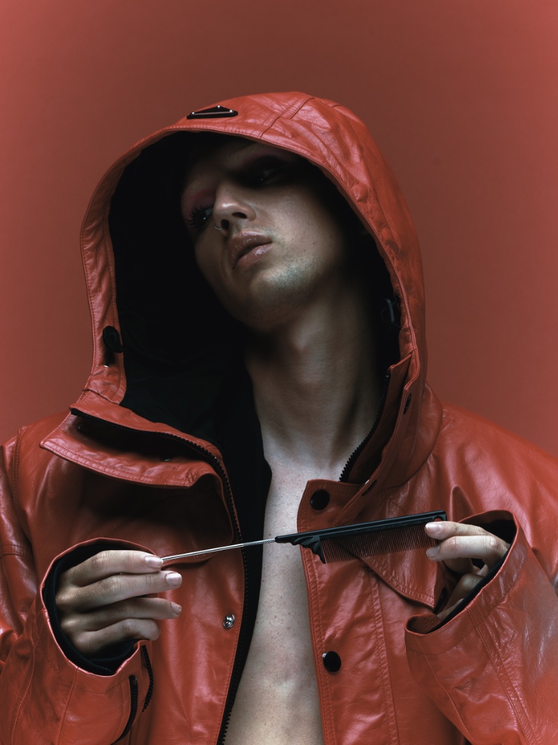 Making a statement in red for VMAN, Troye Sivan dons a red hooded jacket by Prada.