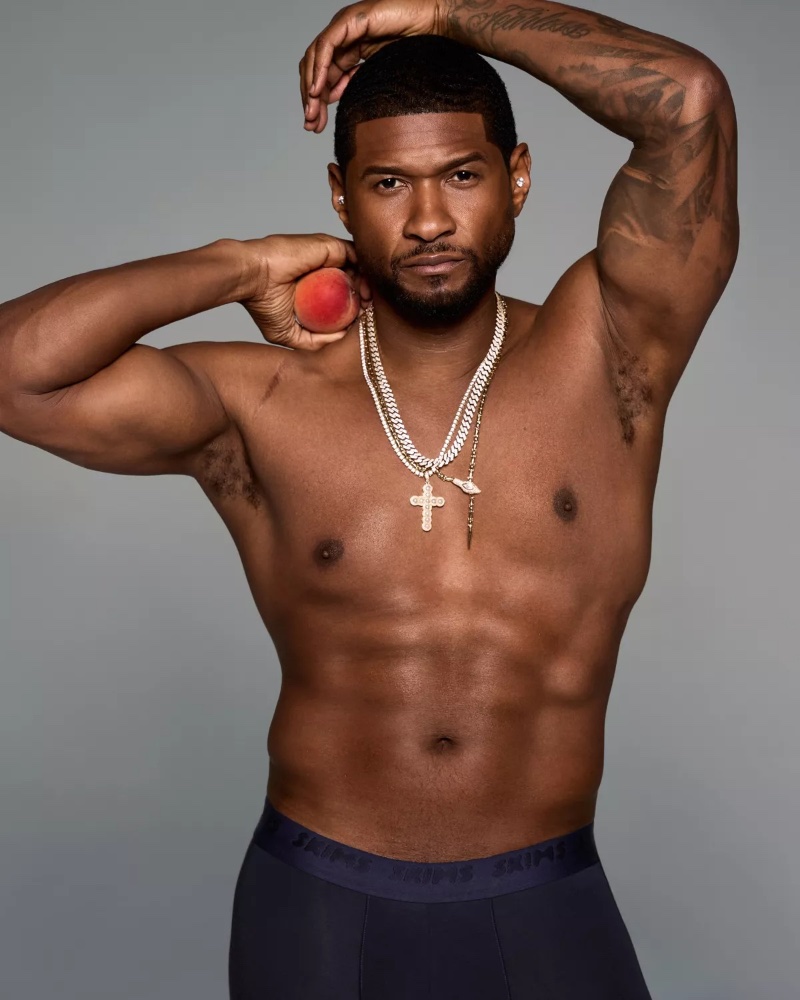 Flaunting a navy SKIMS boxer, Usher pairs his look with layered necklaces.