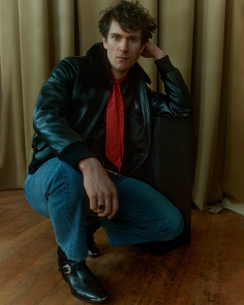 William Bracewell is clad in a Celine leather jacket, classic jeans, a silk-jacquard scarf, and Chelsea boots for Mr Porter.