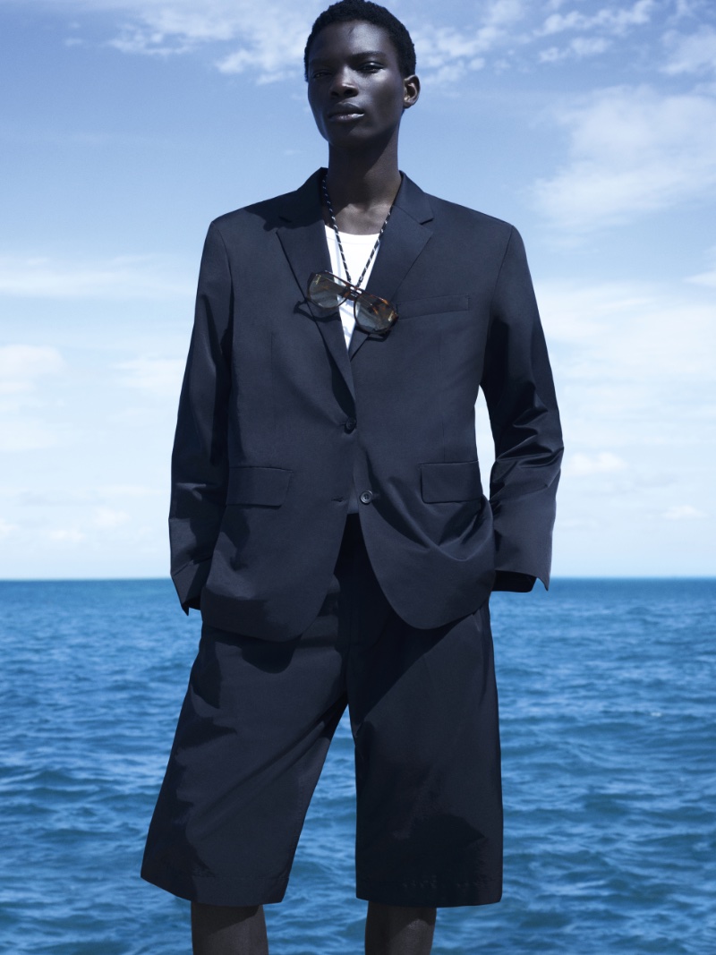 Dara Gueye models a navy short suit for COS' spring-summer 2024 campaign. 