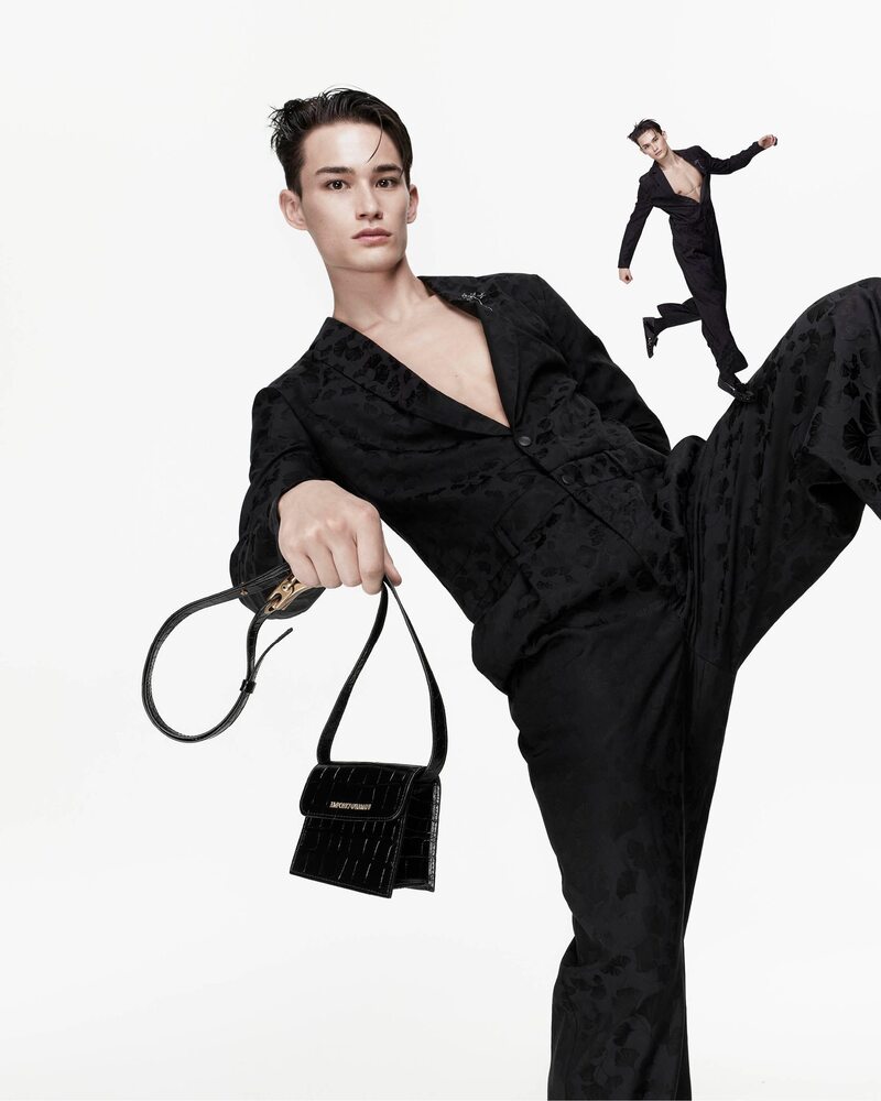 Alex Schlab strikes a pose with a structured Emporio Armani bag, showcasing a sleek, patterned suit for the Spring 2024 campaign.