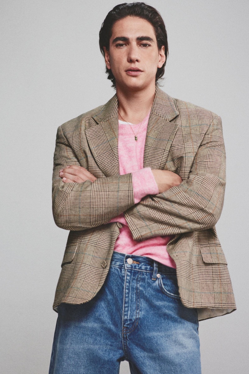 Enzo Vogrincic pairs a plaid blazer with a pink sweater and jeans by Zara.