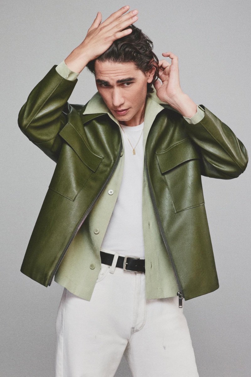 Enzo Vogrincic layers a dynamic olive leather jacket and shirt over a crisp white t-shirt and jeans by Zara.
