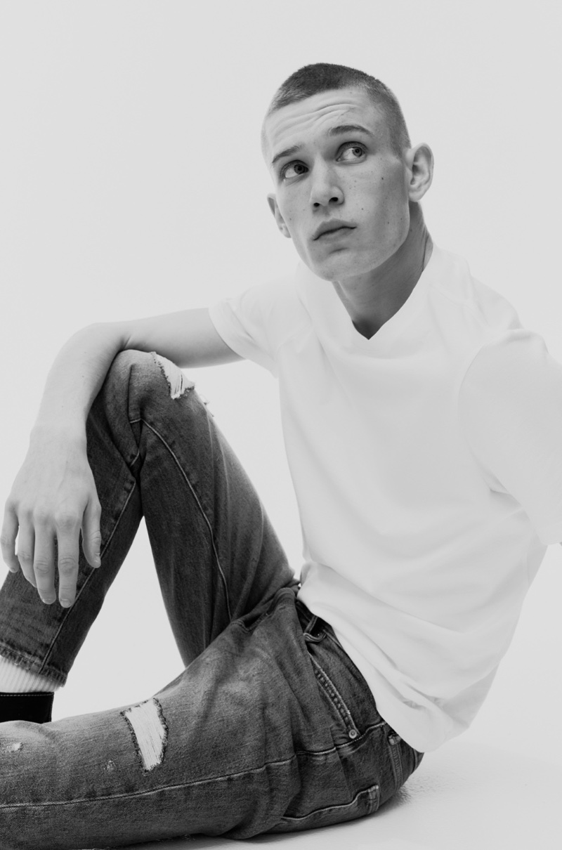 Jake Hodder pairs a crisp white tee with distressed skinny jeans, capturing a minimalist aesthetic.