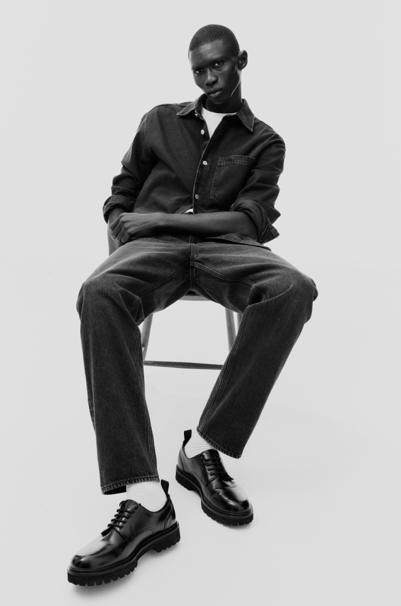 Fernando Cabral elevates a dark denim shirt and jeans with sleek, black chunky-sole shoes.