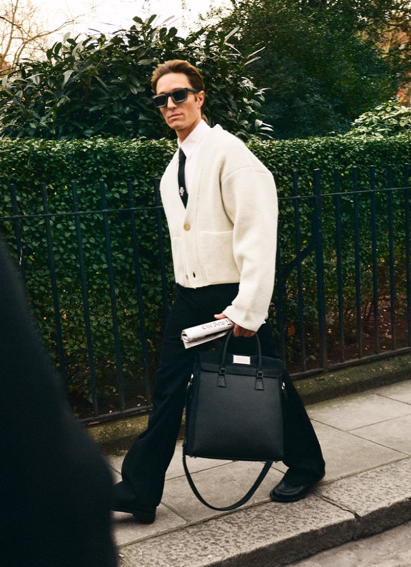 Dancer Francesco Mariottini wears a Hed Mayner cardigan with Louis Vuitton attire, accessorized with a Maison Margiela bag.