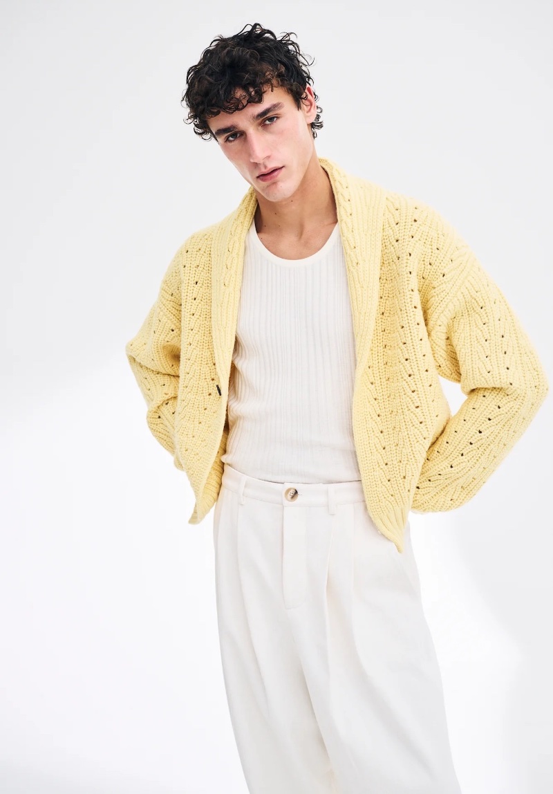 Carlos Galobart channels a relaxed spring-summer vibe in King & Tuckfield's yellow cardigan and white pleated trousers.