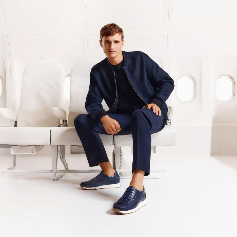Julian Schneyder exudes relaxed sophistication in a navy bomber, trousers, and leather sneakers for the LLOYD spring-summer 2024 campaign.