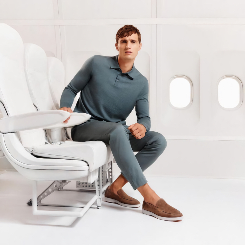 Julian Schneyder showcases effortless elegance in a long-sleeve polo and trousers with brown slip-on shoes for the LLOYD spring-summer 2024 ad.