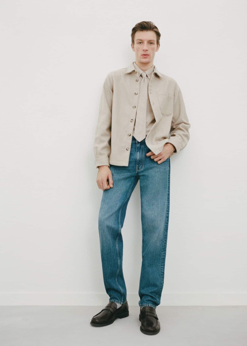 Finnlay Davis models a neutral-toned overshirt and classic blue jeans by Mango.