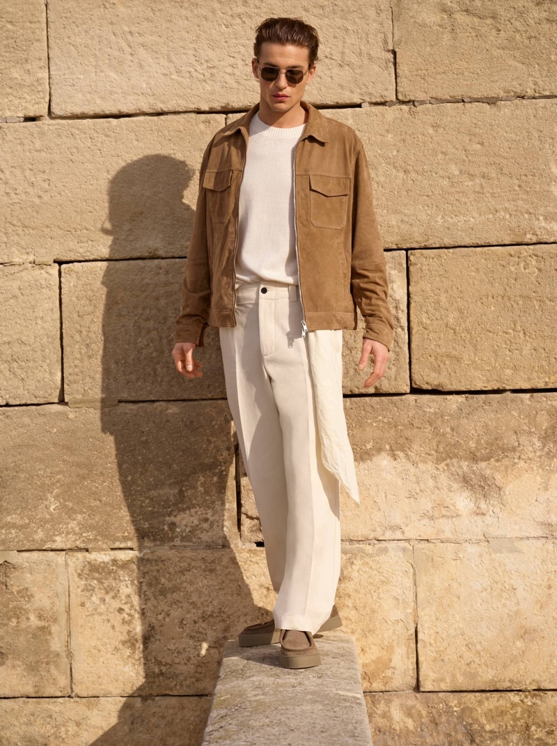Yulef Bopp poses in Massimo Dutti's earth-toned jacket and crisp white trousers.