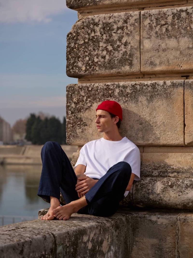 Yulef Bopp relaxes in timeless basics by Massimo Dutti, featuring a crisp white tee and navy trousers.