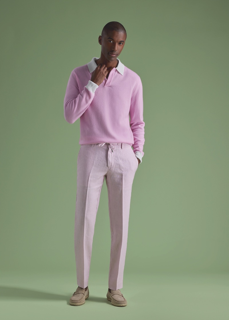 Dressed in pink, Claudio Monteiro models a cashmere open collar polo with linen drawstring trousers and suede penny loafers by Paul Stuart.
