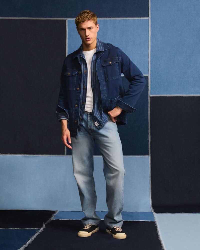 Donning blue layers, Paul François wears a Pepe Jeans denim jacket over a striped shirt.