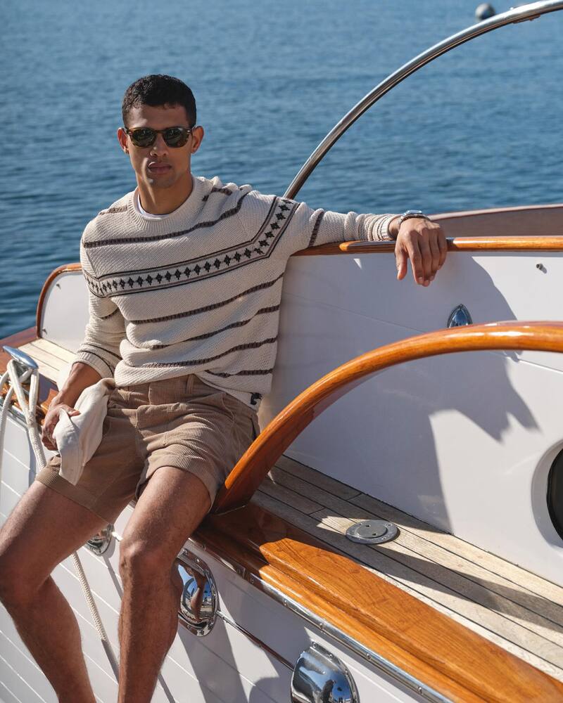 Basking in the sun, Jonas Barros wears a Todd Snyder striped sweater with corduroy camp shorts. 