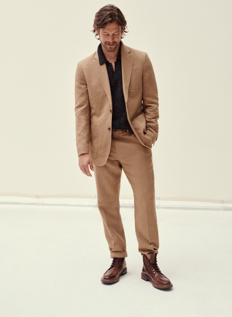 Wearing Banana Republic, Josh Upshaw dons a BR Classics linen-blend suit and linen-cotton sweater polo with a leather D-ring belt and Jaxon leather boots.