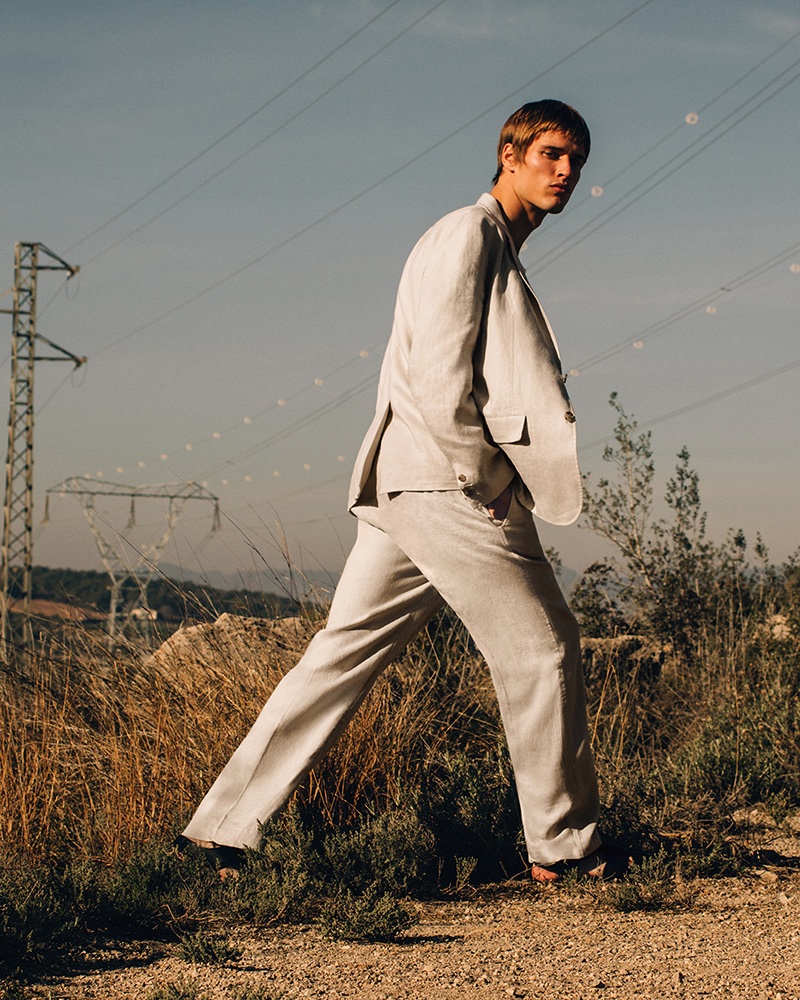Yeray Allgayer cuts a striking figure in a linen suit, showcasing COS' summer 2024 line in the outdoors. 