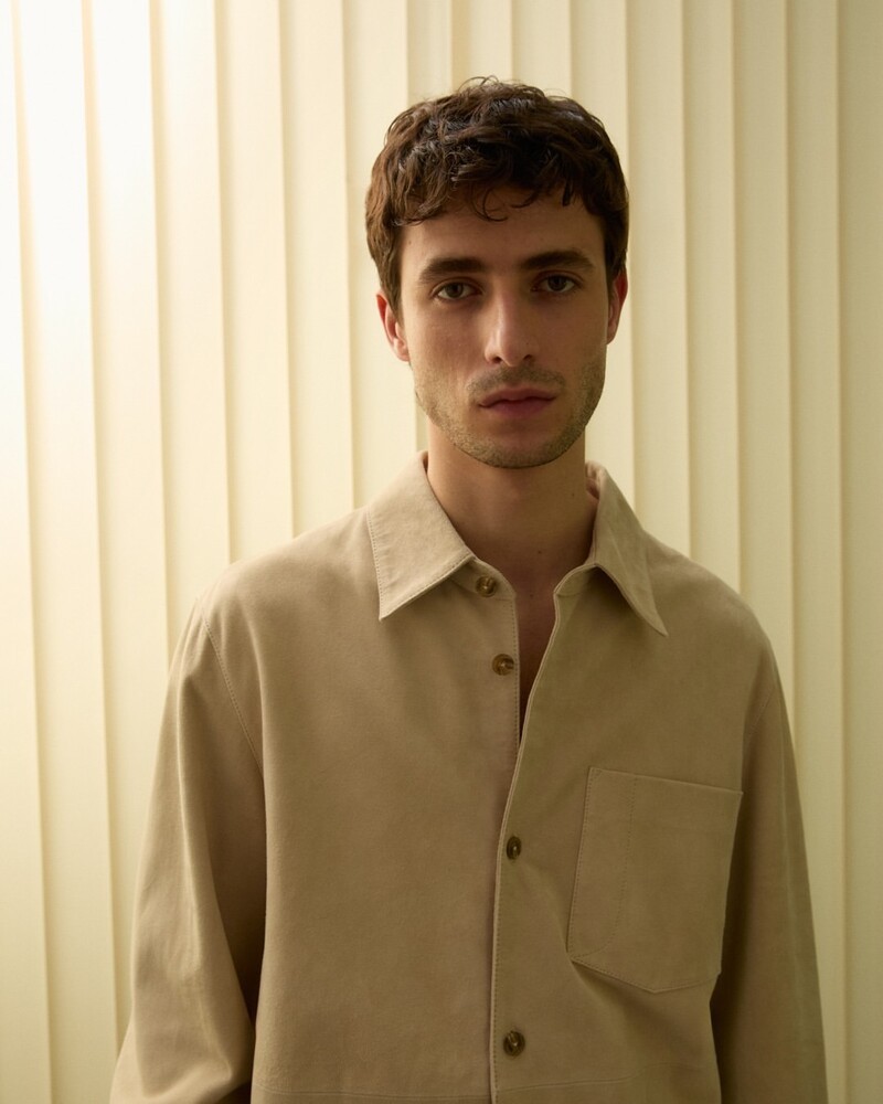 Oscar Kindelan wears a minimalist beige shirt from Closed's summer 2024 collection.