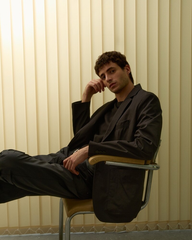 Oscar Kindelan lounges in an unlined blazer from Closed's summer 2024 collection.