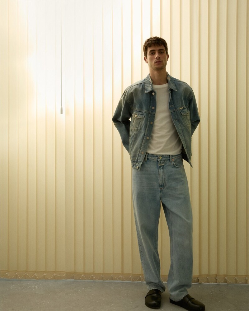 Oscar Kindelan strikes a relaxed pose in a timeless denim-on-denim look for Closed's summer 2024 collection.