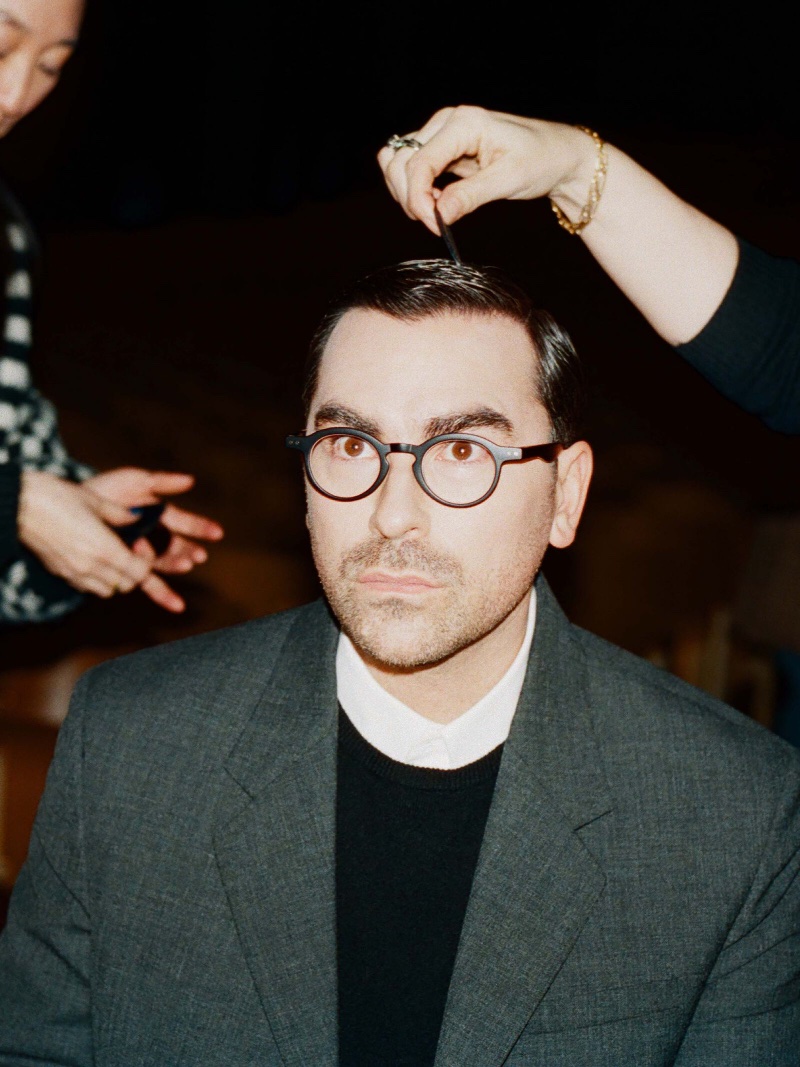 Caught mid-grooming, Dan Levy is the picture of focus in a classic sweater and blazer for LOEWE's campaign.