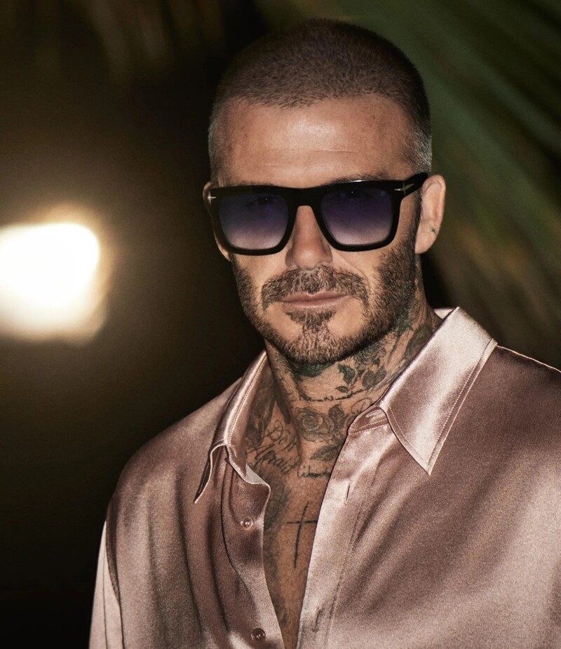 David Beckham channels timeless cool in bold, black sunglasses with a satin shirt for his spring 2024 eyewear campaign.