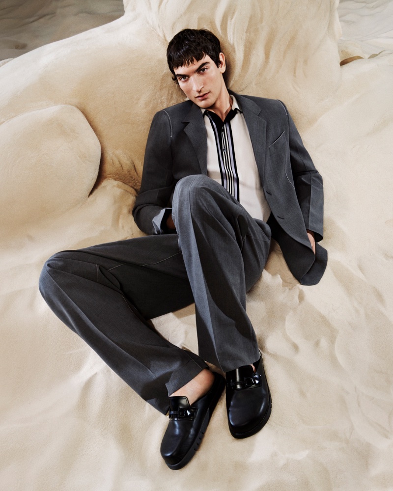 Reclined in refinement, Luca Lemaire sports a sleek suit for Ferragamo's pre-fall 2024 campaign.